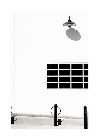 Black lamp on a white wall with grid window and minimal street elements, featured on a poster.