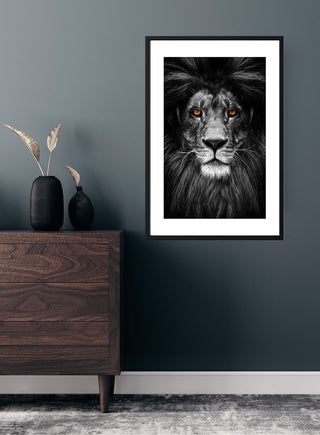Løve poster featuring a black and white lion with piercing eyes, displayed above a modern wooden dresser.