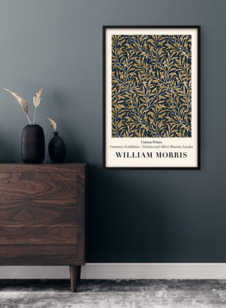 Framed William Morris "Willow Bough" print on a dark wall above a wooden dresser with decorative vases.