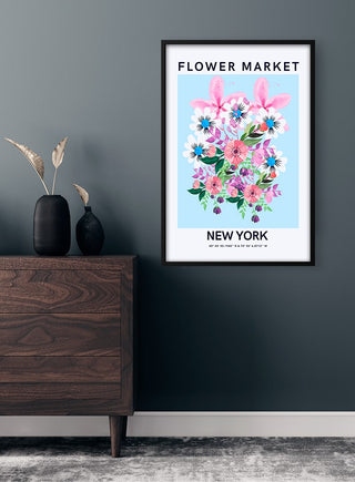 Framed "Flower Market - New York" poster with colorful flowers hanging on a dark green wall above a wooden dresser.