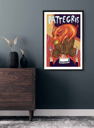 Framed print of "På Hovedet Pattegris" by Nina Broen hanging above a wooden dresser in a modern room.