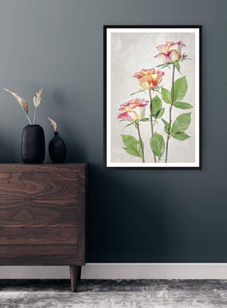 Framed artwork of pink and yellow roses by Mandy Disher hanging above a wooden dresser in a modern room.