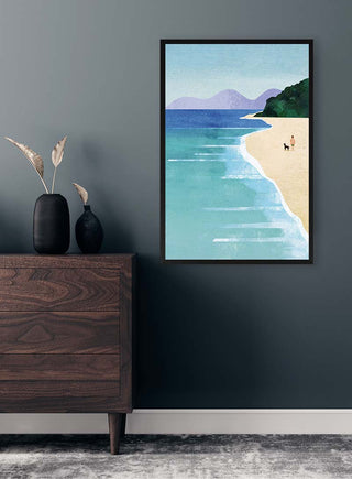 Framed Beach Girl II by Henry Rivers above a wooden dresser, featuring a serene beach with distant mountains.