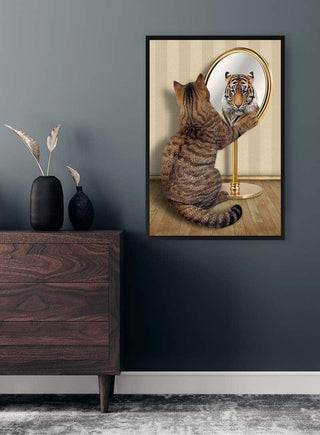 A framed artwork of a cat seeing a tiger in the mirror, displayed above a wooden dresser.