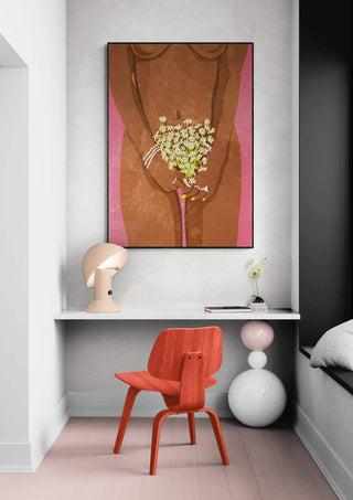 Framed "Wearing Flowers" by Raissa Oltmanns displayed above a desk with a red chair in a modern room.