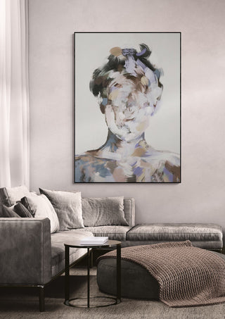 Abstract portrait painting by Gabriella Roberg displayed above a modern gray sofa in a stylish living room.