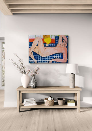 Pink Nude 1935 by Henri Matisse hanging above a wooden console table in a modern living room setting.