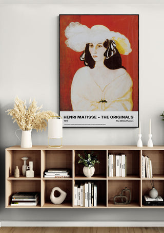Framed print of Henri Matisse's "The White Plumes" displayed above a modern bookshelf in a stylish living room.