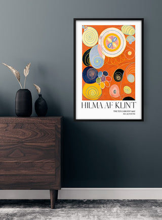 Framed "Youth No. 3" poster by Hilma af Klint hanging on a dark wall above a wooden dresser with vases.