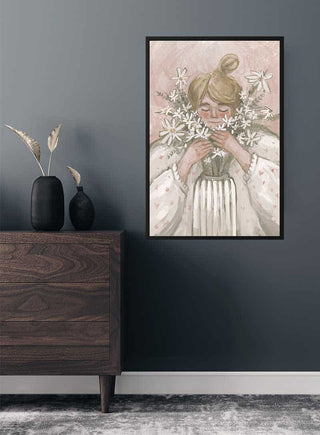 Framed "Flowergirl in Pink" art print hanging on a gray wall above a wooden sideboard with vases.