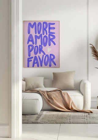 Framed "More Amor Por Favor" Baroo Bloom print hanging above a modern white sofa with beige pillows and throw.