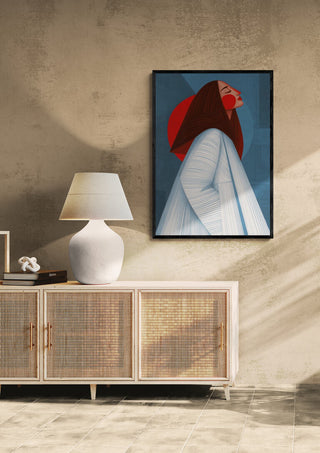 Red Sun by Martina Karlsson framed on a beige wall above a sideboard with a white lamp and decor items.