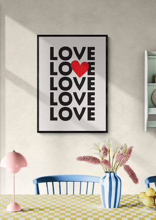 Framed print with repeated word "LOVE"; second "O" is a red heart; modern decor in stylish room.