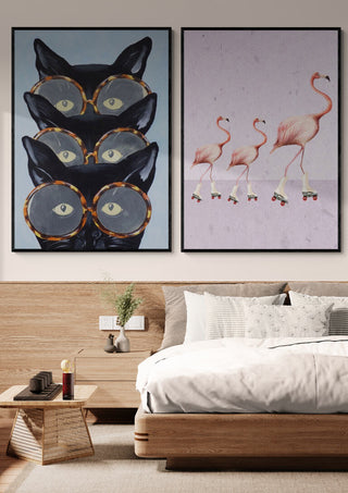 Framed wall art of three black cats with glasses, Coco de Paris style, displayed above a modern bed.