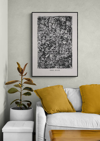 Framed Small World 1914 by Paul Klee hanging above a sofa with yellow pillows in a modern living room.