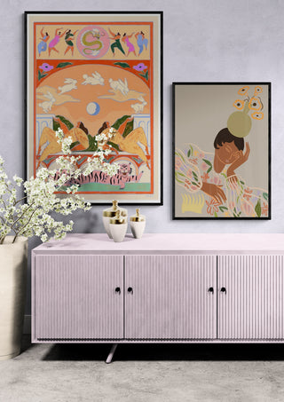 Framed "Rabbit Jumps Over the Moon" by Arty Guava displayed above a pink cabinet in a modern room.