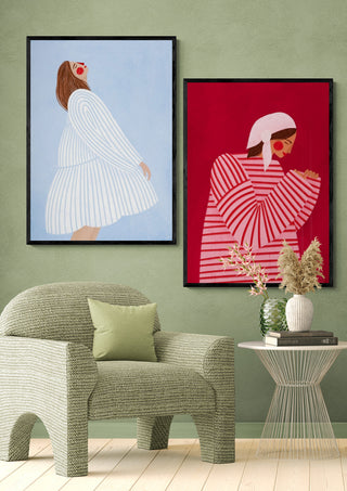 Framed print of "The Woman With the Blue Stripes" by Bea Muller displayed above a modern chair and table.