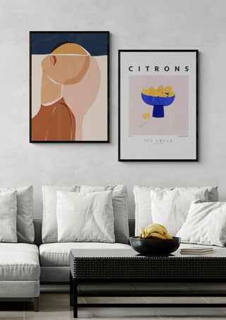 Half Face Half Sun - Ivy Green art print displayed above a modern sofa beside another framed artwork.